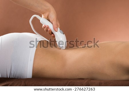 Close-up Of Young Woman Receiving Laser Treatment On Back