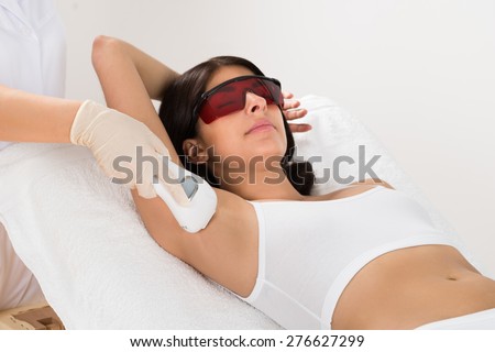 Woman Receiving Epilation Laser Treatment On Armpit At Beauty Clinic