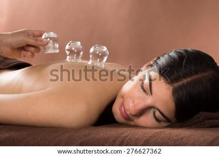 Woman Lying On Front Receiving Cupping Treatment On Back