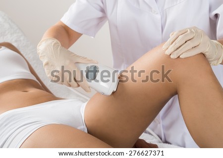 Close-up Of Woman Having Laser Treatment At Beauty Clinic On Thigh