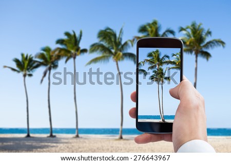 Close-up Of Person Hand Photographing Beach With Mobile Phone