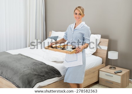 Happy Maid Carrying Breakfast Tray In Hotel Room