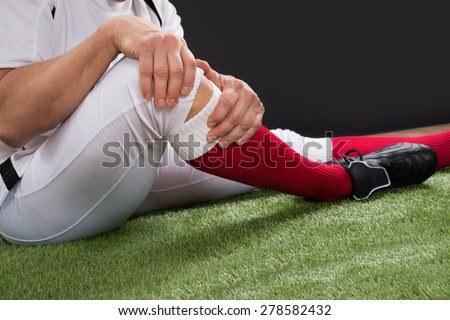 Close-up Of A American Football Player With Injury In Leg On Field