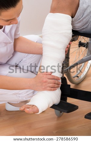 Close-up Of A Female Doctor Holding Disabled Patient\'s Leg