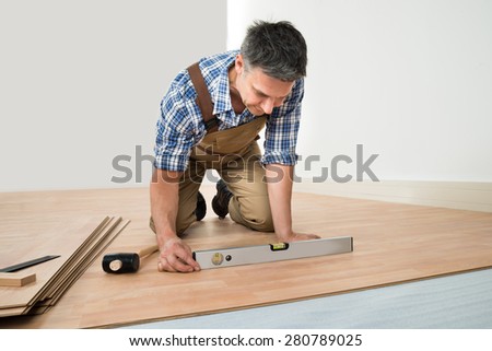 Carpenter Installing New Laminated Wooden Floor At Home