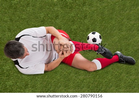 Male Soccer Player Suffering From Injury In Knee