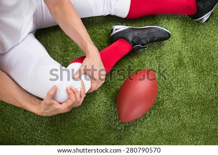 Close-up Of A American Football Player With Injury In Leg On Field