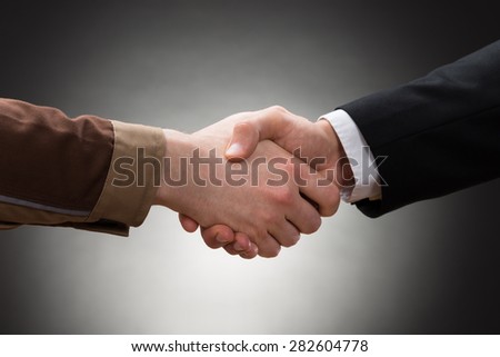 Close-up Of A Worker And Businessman Shaking Hand