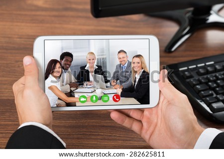 Close-up Of Businessperson Video Conferencing On Mobile Phone In Office