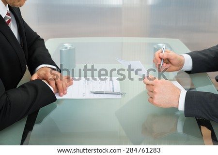 Businessman Conducting An Employment Interview With Application Form On Office Desk