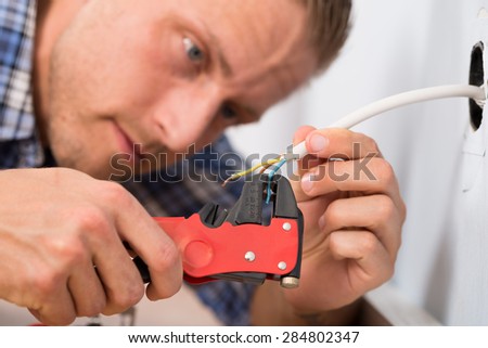 Close-up Of Electrician Stripping Wires For With Wire Stripping Plier