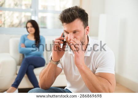 Wife With Curiosity Looking At Husband Talking Privately On Cellphone