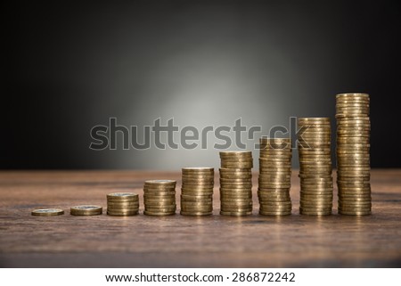 Close-up Of Coins Stack On Wooden Table