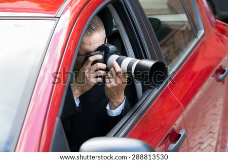 Close-up Of A Male Driver Photographing With Slr Camera From Car