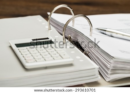 Close-up Of Invoice With Calculator And Pen On Desk