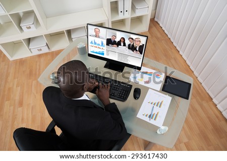High Angle View Of Businessman Video Conferencing With Colleague On Computer In Office
