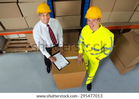 Happy Warehouse Worker And Manager Checking Inventory In Warehouse