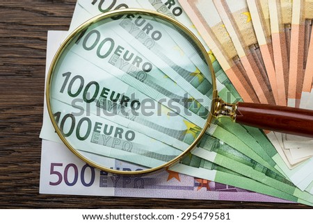 Close-up Of Magnifying Glass Over Euro Banknote