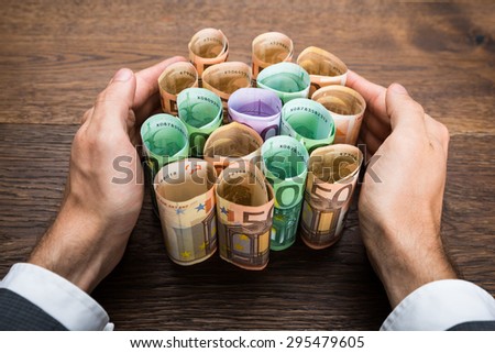Close-up Of A Businessman\'s Hand Protecting Euro Banknotes