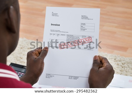 Close-up Of African Young Man Holding Invoice With Final Demand Notification