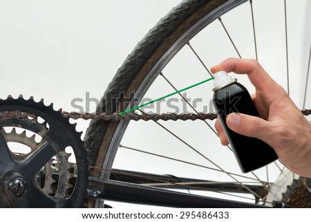 Close-up Of Person Hands Lubricating Bike Chain