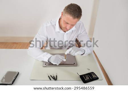 Photo Of Young Repairman Repairing Laptop At Desk