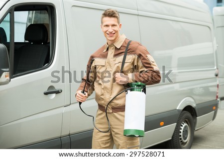 Young Male Worker With Pesticide Standing Near The Van