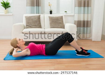 Young Happy Woman Doing Exercise In House