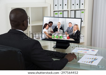 Young African Businessman Video Chatting With Colleagues On Computer In Office