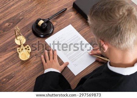 Close-up Of Judge Writing On Paper In Courtroom
