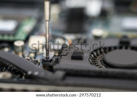Close-up Of Person Hands In Glove Repairing Laptop Motherboard