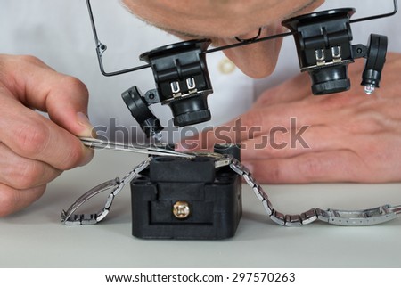 Close-up Of Watchmaker Using Loupe For Repairing Wrist Watch