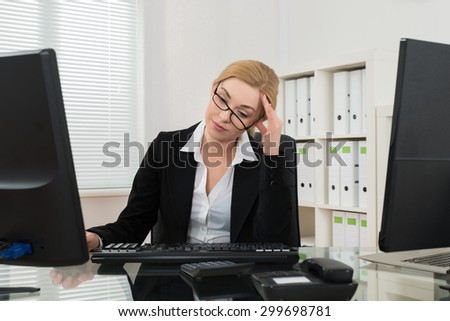 Young Businesswoman Having Headache At Desk In Office