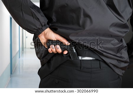 Close-up Photo Of Bodyguard Hands Removing Handgun