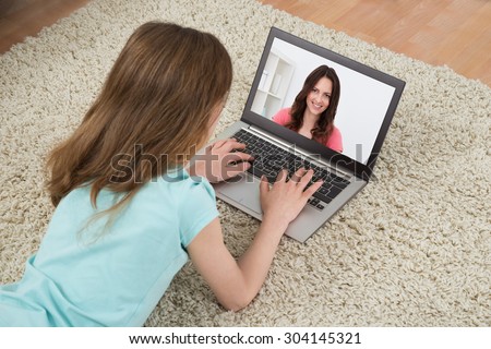 Girl Video Chatting With Woman On Laptop In House