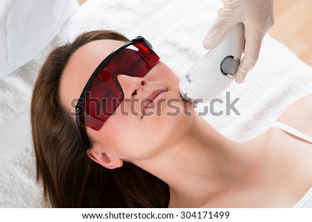 Young Woman Receiving Epilation Laser Treatment On Face At Beauty Center