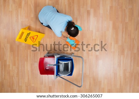 High Angle View Of Woman Cleaning Floor With Rag