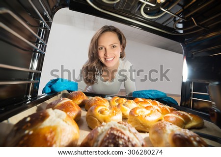 Young Woman Removing Bun Tray View From Inside Microwave Oven