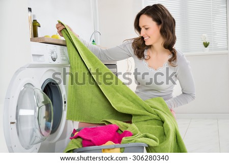 Young Happy Woman Laundering Clothes In Electronic Washer