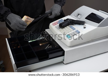 Close-up Of Robber Hands Taking Paper Money From Cash Register