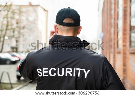 Close-up Of Male Security Guard Wearing Black Jacket
