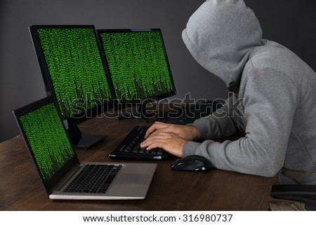 Hacker Typing On Computers With Binary Code At Desk