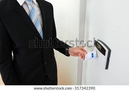 Close-up Of Businessperson Hands Holding Keycard To Open Door