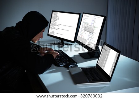 Male Hacker Using Computers To Steal Data In Office