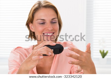 Close-up Of Young Happy Woman Checking Glucose Level With Glucometer