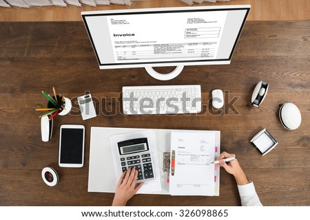 High Angle View Of Young Male Accountant Checking Invoice In Office