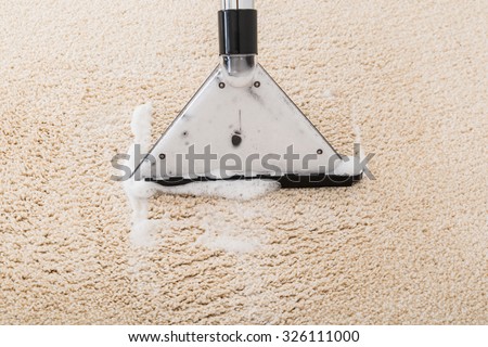 Close-up Of Vacuum Cleaner With Foam Over Wet Carpet