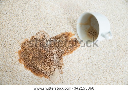 Close-up of coffee spilling from cup on carpet