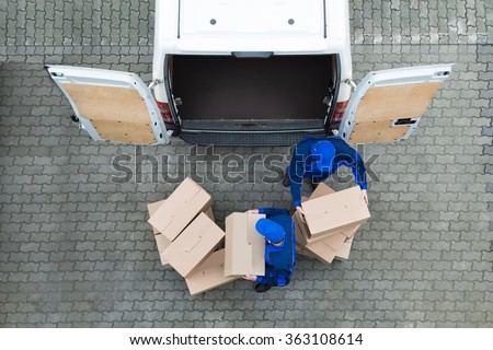Directly above shot of delivery men unloading cardboard boxes from truck on street