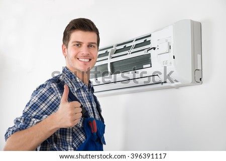 Young Happy Male Technician Gesturing Thumb Up